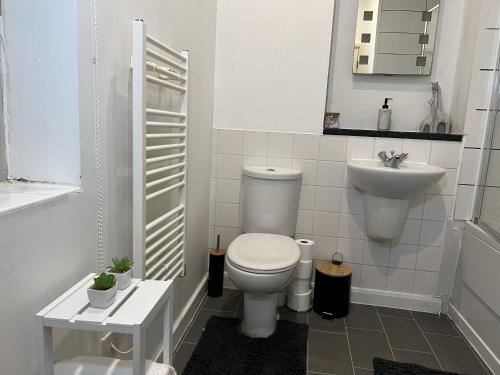 a white bathroom with a toilet and a sink at Peaceful Coventry Retreat - Free parking in Coventry