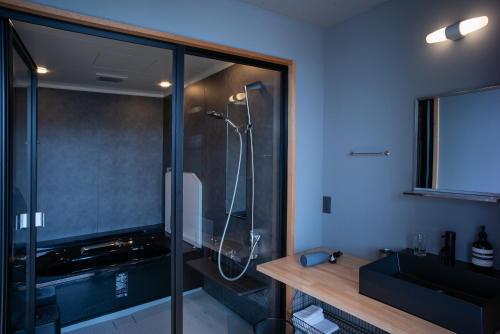 a bathroom with a shower with a glass wall at Lhotel de Mai in Tamba-sasayama
