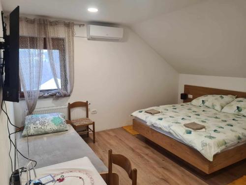 Schlafzimmer mit einem Bett, einem Tisch und einem Fenster in der Unterkunft Turistično - Izletniška kmetija Žerjav in Brežice