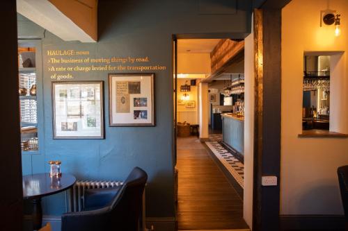a dining room with a table and a blue wall at The Dog in Over Peover in Knutsford