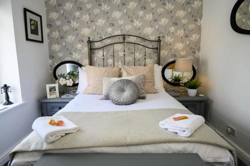 a bedroom with a bed with two towels on it at Poet's Cottage by StayStaycations in Aberdare