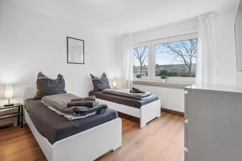 um quarto com 2 camas e uma janela em SC01 Großes Apartment bei FFM! em Mörfelden-Walldorf