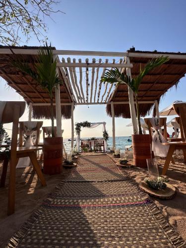 a pathway on the beach with tables and chairs at Cristal Blue Barú in Baru