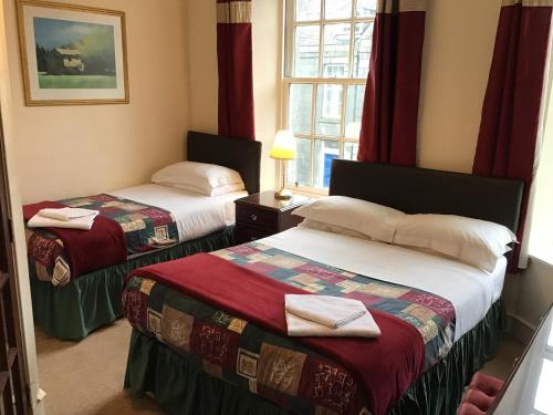 a hotel room with two beds and a window at The Royal Crown Guest House in Aberdeen