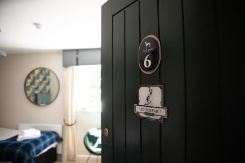 a black door with a sign on it in a room at The Dog in Over Peover in Knutsford