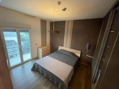 een slaapkamer met een bed en een groot raam bij Villa 25 minutes from Lisbon & 10 min from the sea in Quinta do Anjo