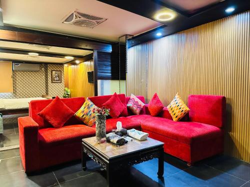 a living room with a red couch and a table at Hotel SeaView 2 in Karachi
