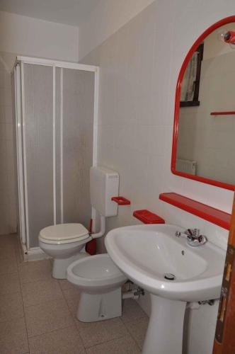 a bathroom with a sink and a toilet and a mirror at Apartments in Pieve di Ledro/Ledrosee 22632 in Ledro