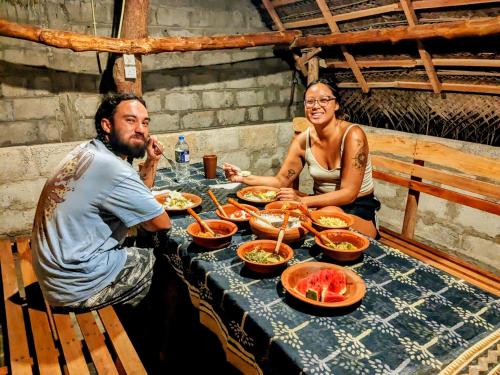 a man and a woman sitting at a table with food at Udawalawa Safari House in Udawalawe