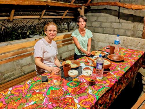 two women standing at a table with food on it at Udawalawa Safari House in Udawalawe