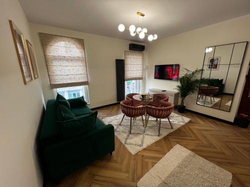 a living room with a green couch and a table and chairs at Apartament Starówka Bulvar 11 in Elblag