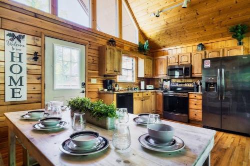 a kitchen with a table with bowls and plates on it at Joy's Retreat Cabin in Sevierville