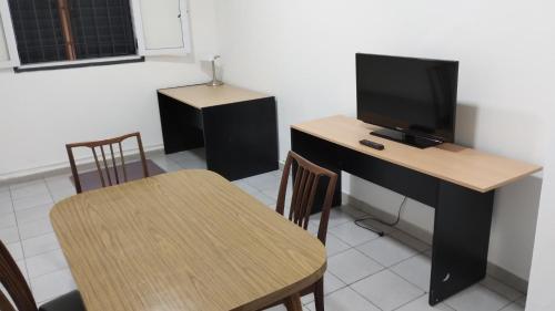 a room with a desk with a tv and a table with chairs at Orense in La Rioja