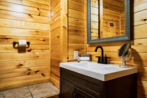 a bathroom with a sink and a mirror at Joy's Retreat Cabin in Sevierville