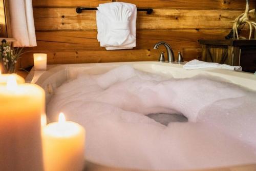 a bath tub filled with snow next to two candles at Joy's Retreat Cabin in Sevierville
