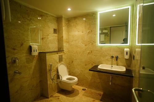 a bathroom with a toilet and a sink and a shower at HOTEL PRAHLAD INN in Gwalior