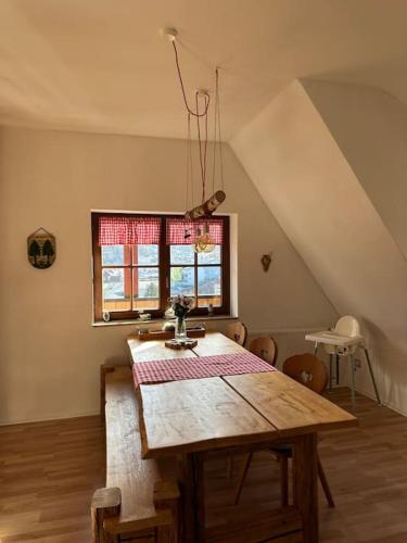 ein Esszimmer mit einem Holztisch und einem Fenster in der Unterkunft Typical home in the Black Forest in Bad Wildbad