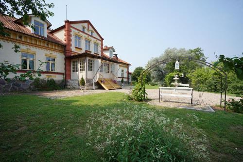 a house with a gate in front of a yard at Marcienas Muiza & SPA in Mārciena
