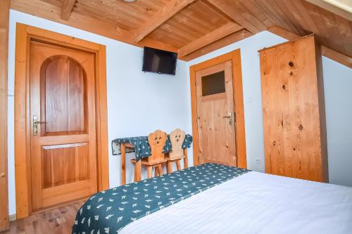 a bedroom with a bed and a wooden door at Willa Pod Orłem Jacuzzi Sauna in Kościelisko