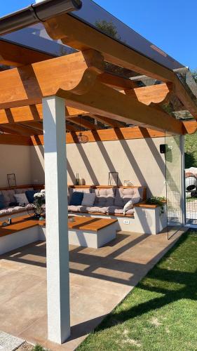 une pergola en bois avec des canapés sur une terrasse dans l'établissement Villa Diva, à Budureasa