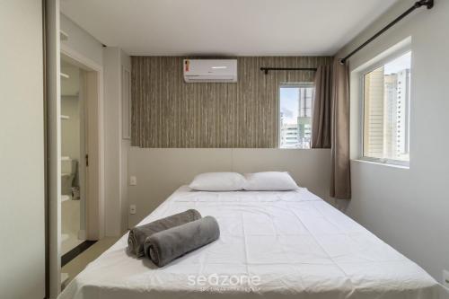 1 dormitorio con 1 cama blanca grande y 2 almohadas en Apto lindo prox do mar em Balneário YVD1301, en Balneário Camboriú