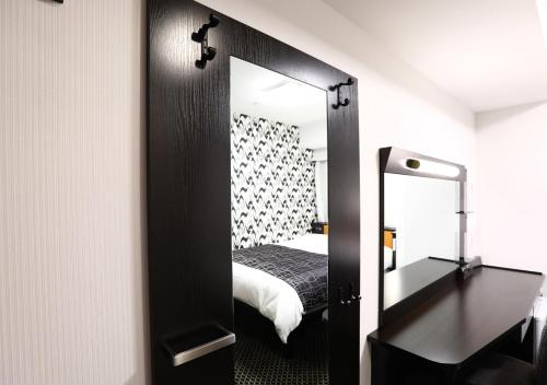 a bedroom with a mirror and a bed in a room at APA Hotel Osaka Temma in Osaka