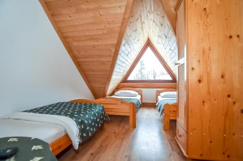 a room with two beds and a window at Willa Pod Orłem Jacuzzi Sauna in Kościelisko