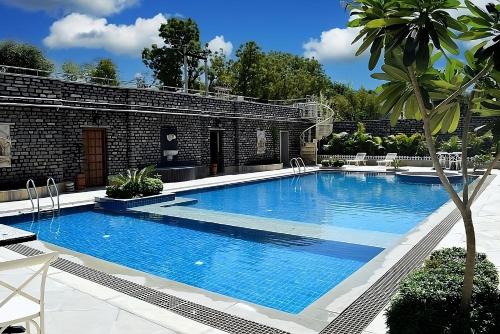 Bazén v ubytování THE TRISHALA VILAS (A LUXURY BOUTIQUE HOTEL & SPA) nebo v jeho okolí