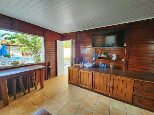 cocina grande con paredes de madera y TV de pantalla plana. en Pousada Suítes do Atlântico en Ilhéus