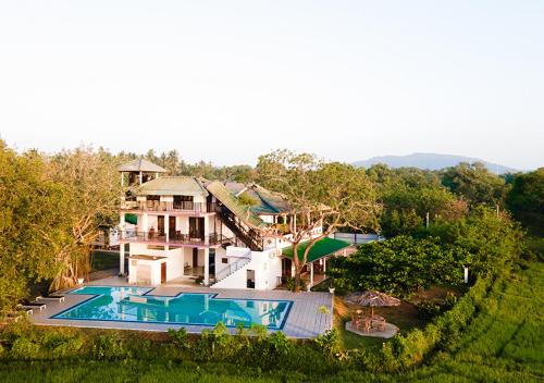 an aerial view of a house with a swimming pool at Birdsong Leisure Resort in Tissamaharama