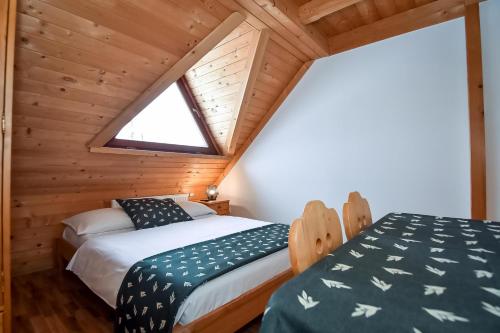 a bedroom with two beds in a wooden cabin at Willa Pod Orłem Jacuzzi Sauna in Kościelisko