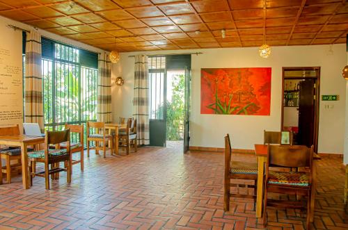 a restaurant with tables and chairs and a painting on the wall at Susa Gardens in Ruhengeri