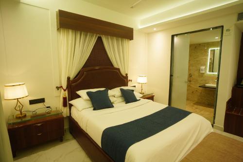 a bedroom with a large bed and a shower at HOTEL PRAHLAD INN in Gwalior