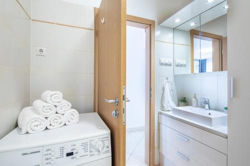 a bathroom with a sink and a washing machine at LOTUS Apartments ORIGO with Garage in Budapest