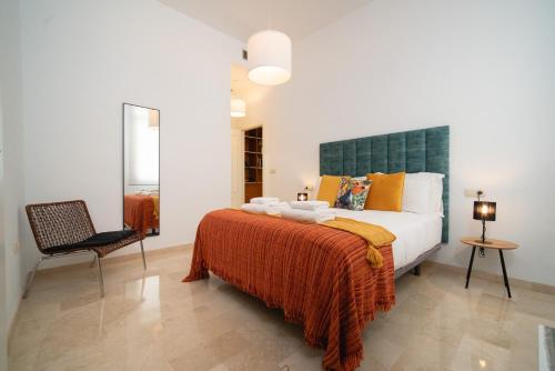 a bedroom with a large bed and a chair at Apartamento Castilla 61 by SHS in Seville