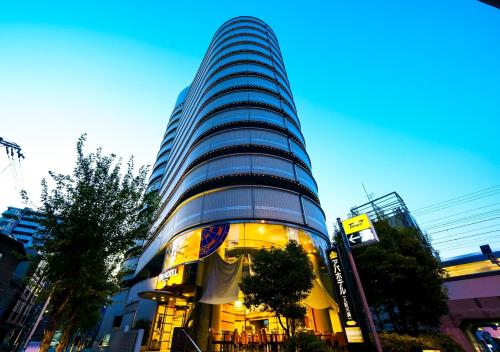 ein hohes Gebäude mit Licht in einer Stadt in der Unterkunft APA Hotel Osaka-Temma in Osaka