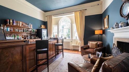 una sala de estar con un bar con sofá y sillas en Durn House, en Portsoy