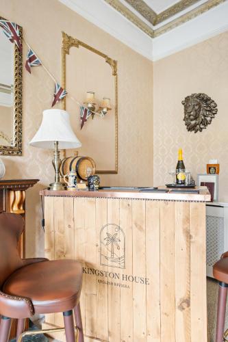 a bar in a room with a mirror and a stool at Kingston House in Torquay