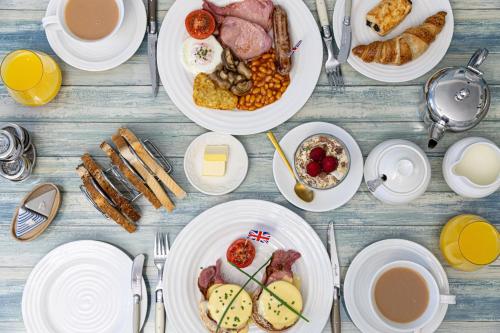 a table with plates of breakfast foods and coffee at Kingston House in Torquay