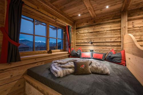 1 dormitorio con 1 cama en una cabaña de madera en Chalets Almdorf Haidenberg, en Brunico