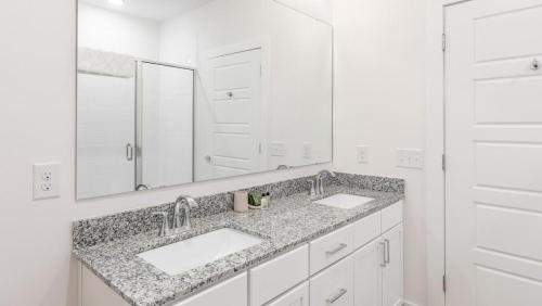 Baño blanco con 2 lavabos y espejo en Landing Modern Apartment with Amazing Amenities (ID4314X66), en Charleston