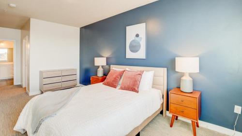 um quarto azul com uma cama e 2 candeeiros em Landing Modern Apartment with Amazing Amenities (ID6877) em South Salt Lake