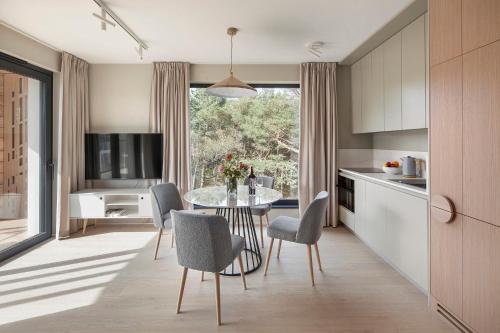 a kitchen and dining room with a table and chairs at Apartamenty na Półwyspie Wydma&Las in Jastarnia