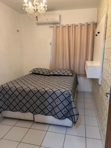 a small bedroom with a bed and a chandelier at APARTAMENTO CONFORTO in São Luís