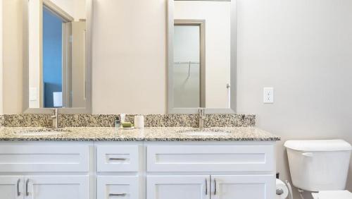 een witte badkamer met 2 wastafels en een toilet bij Landing Modern Apartment with Amazing Amenities (ID8577X56) in Cornelius