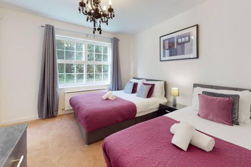 een slaapkamer met 2 bedden en een raam bij Stunning 2-Bed Apartment in Grays in Grays Thurrock