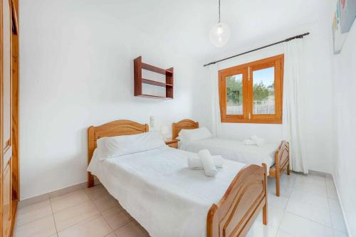 1 dormitorio con 2 camas y ventana en Can Cladera en Playa de Muro