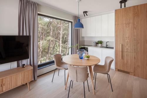 a kitchen and dining room with a table and chairs at Apartamenty na Półwyspie Wydma&Las in Jastarnia