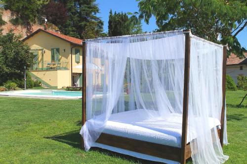 a bed with a canopy in a yard at LA CUCCAGNA DI DON BOSCO - No landlords and neighbours - Absolute privacy! in Montafia