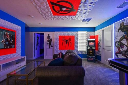 a person laying on a couch in a room with a video game at Magic Marvel Getaway in Kissimmee